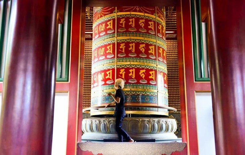 Du khách xoay bánh xe cầu nguyện lớn tại ngôi chùa Răng Phật ở Singapore.