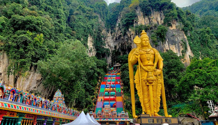 Những bậc thang cầu vồng dẫn lên động Batu, với bức tượng thần Murugan khổng lồ.