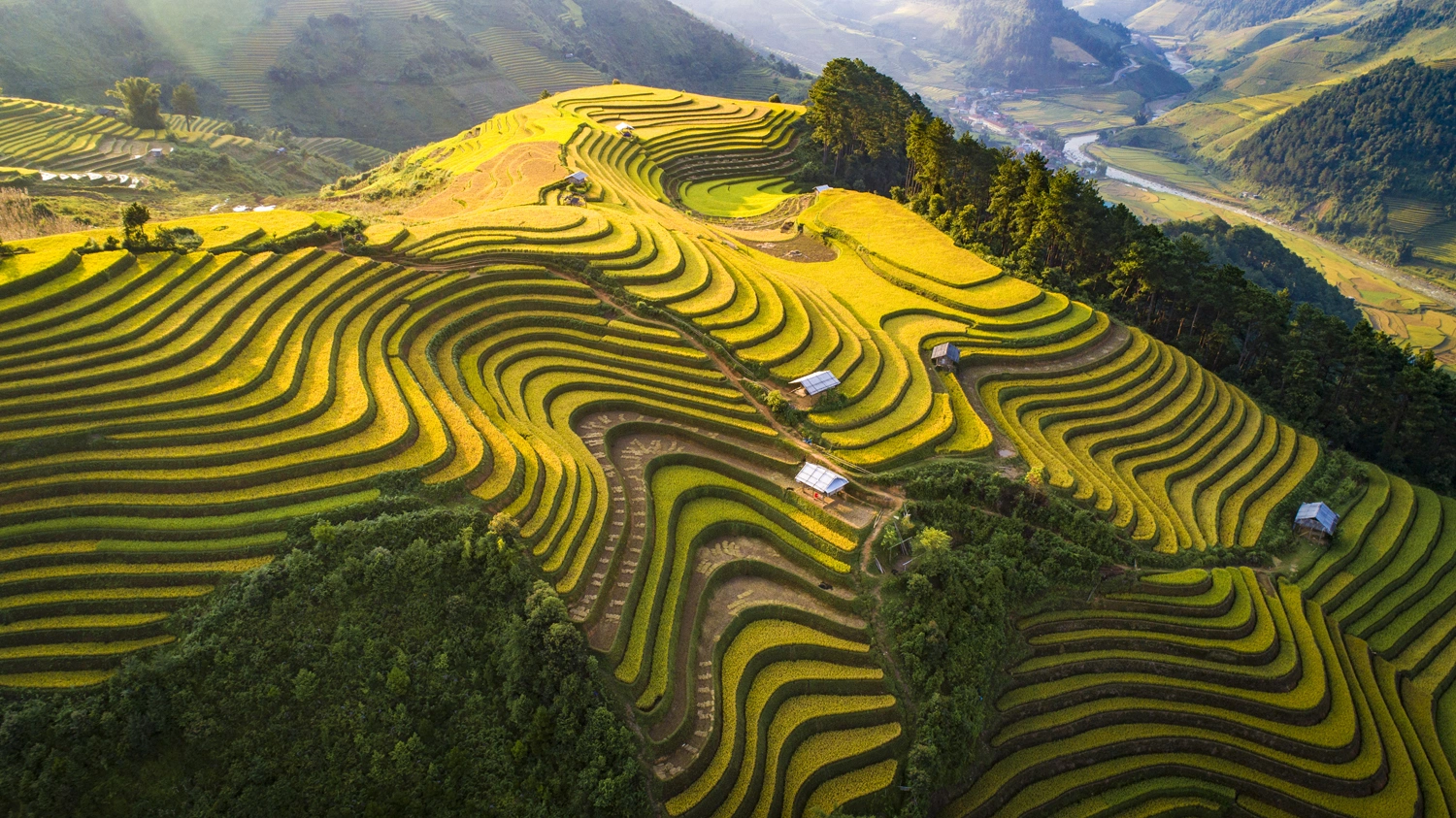 Thung lũng Tú Lệ nhìn từ trên cao, bao quanh bởi những ngọn đồi được phủ bởi ruộng bậc thang và một con đường nhỏ xuyên qua.